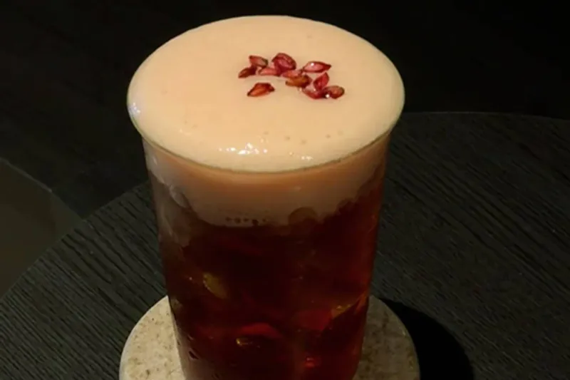 Pomegranate & Earl Grey coffee with citrus foam and pomegranate seeds
